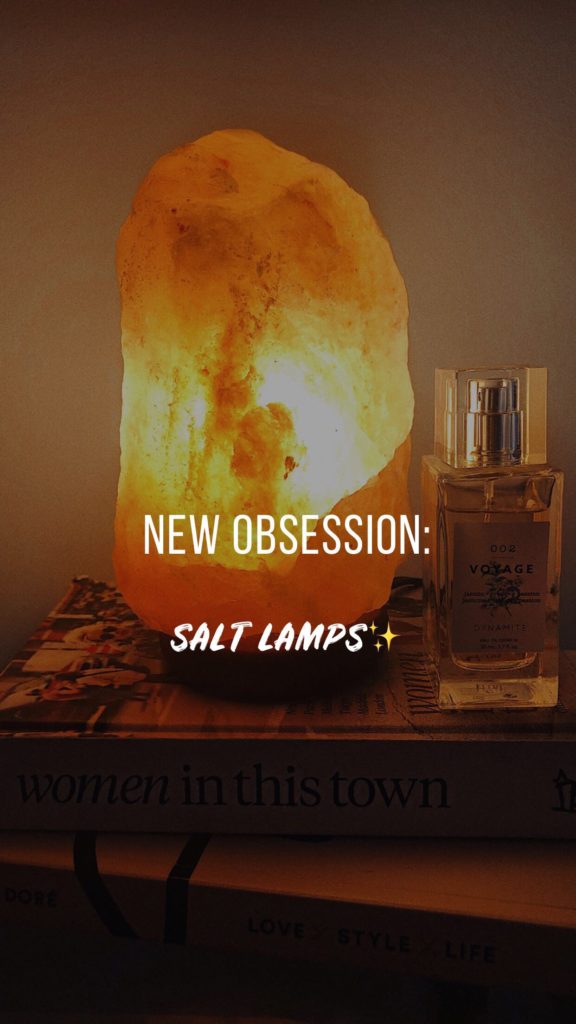 Salt lamp on book with perfume